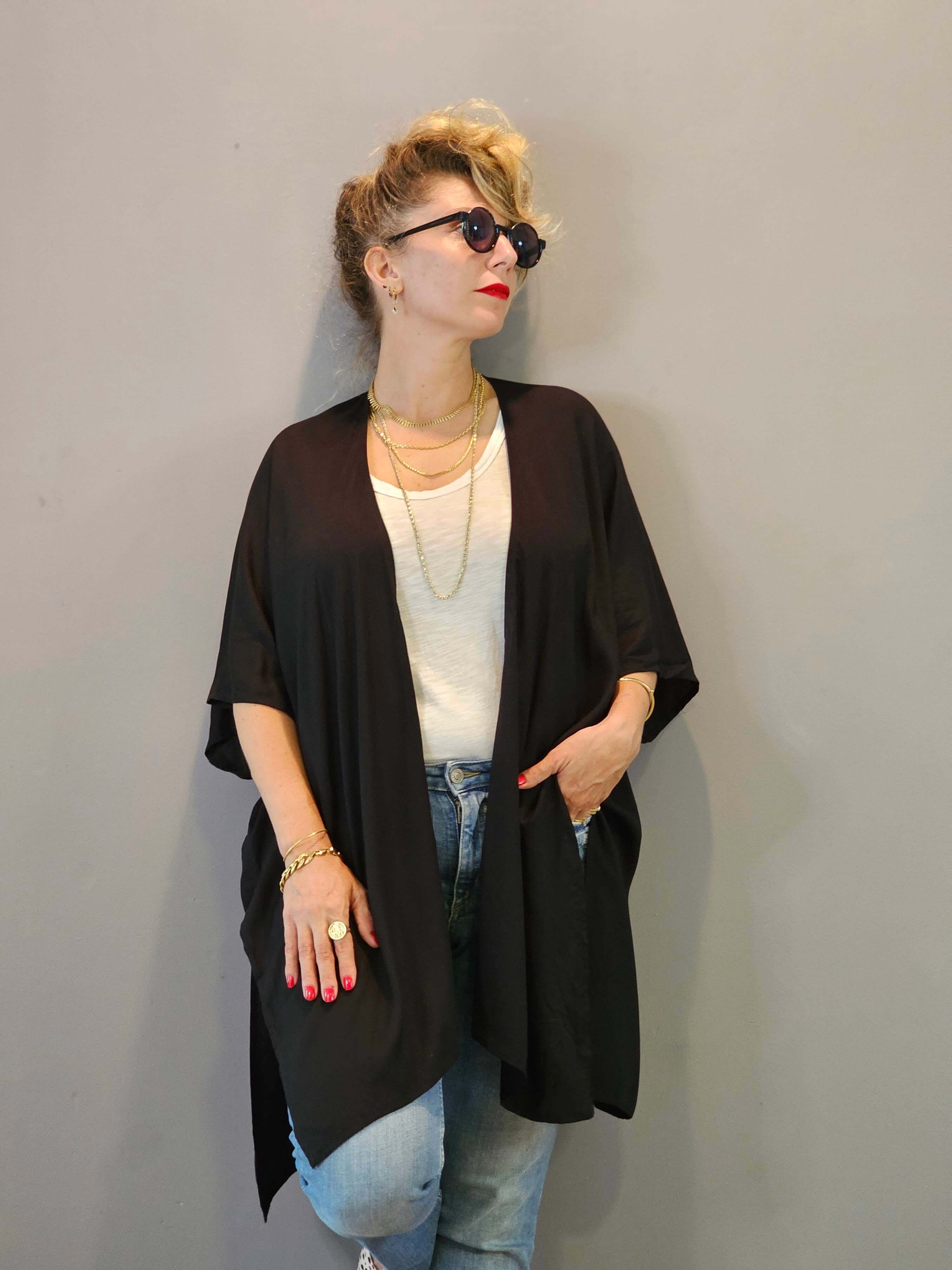 Person wearing a black kimono-style garment against a plain background