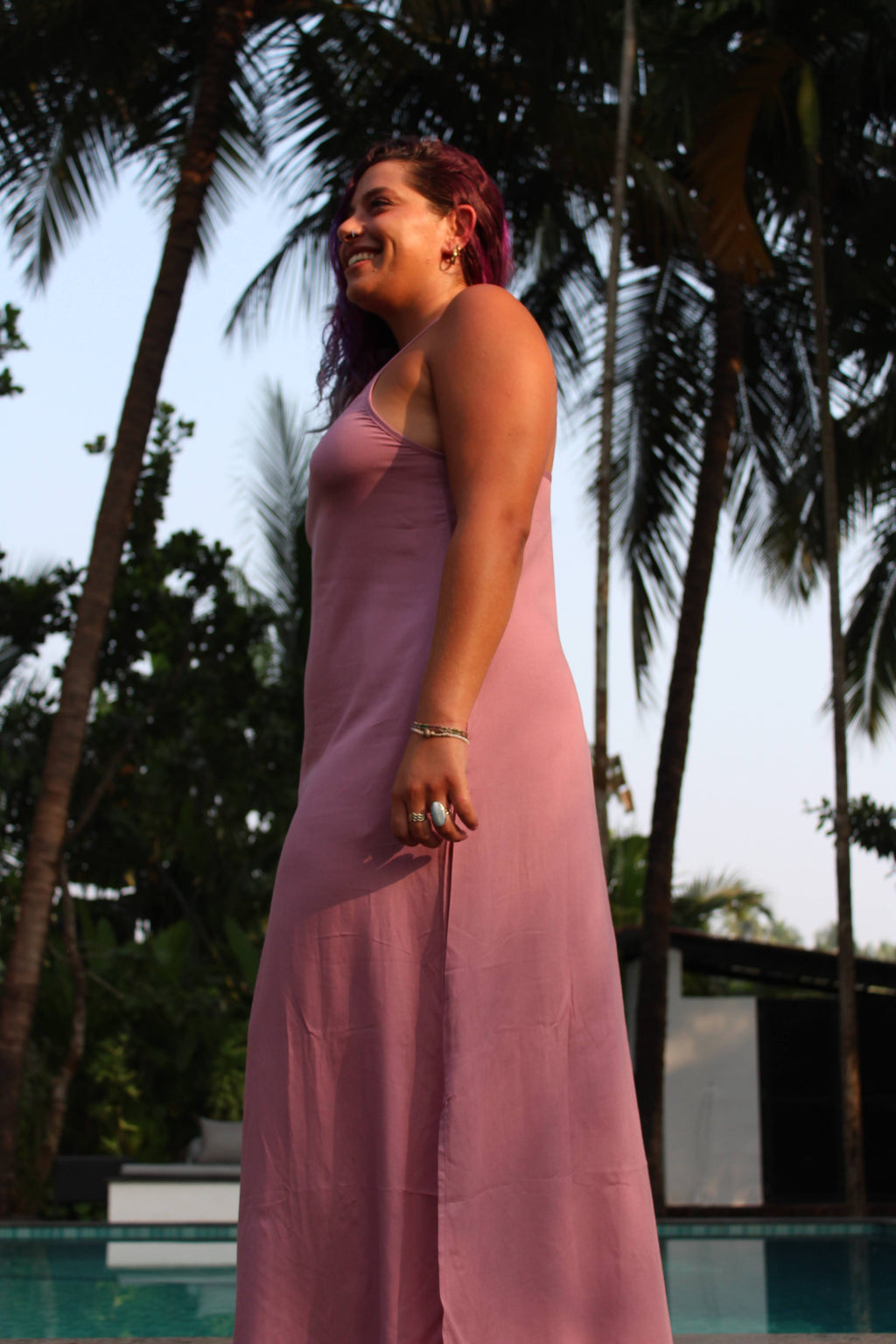 Person wearing a pink dress with palm trees in the background